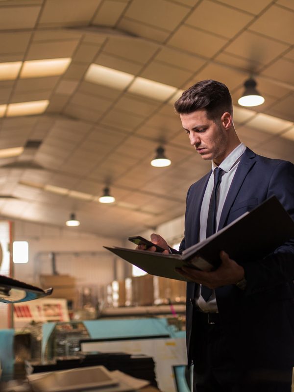 MR_JoseRomera.jpg, PR_Atinta.jpg Young confident supervisor in formal suit holding folder and smartphone while committing†inspection.